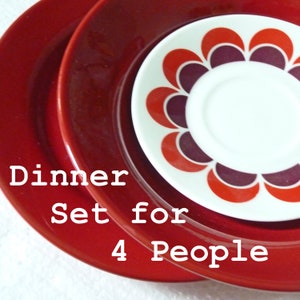 Könnte beinhalten: Ein Geschirr-Set mit einem Stapel Teller in Rot- und Weißtönen. Der obere Teller hat ein Blumendesign in Rot, Orange und Lila. Der Text "Dinner Set for 4 People" ist sichtbar.