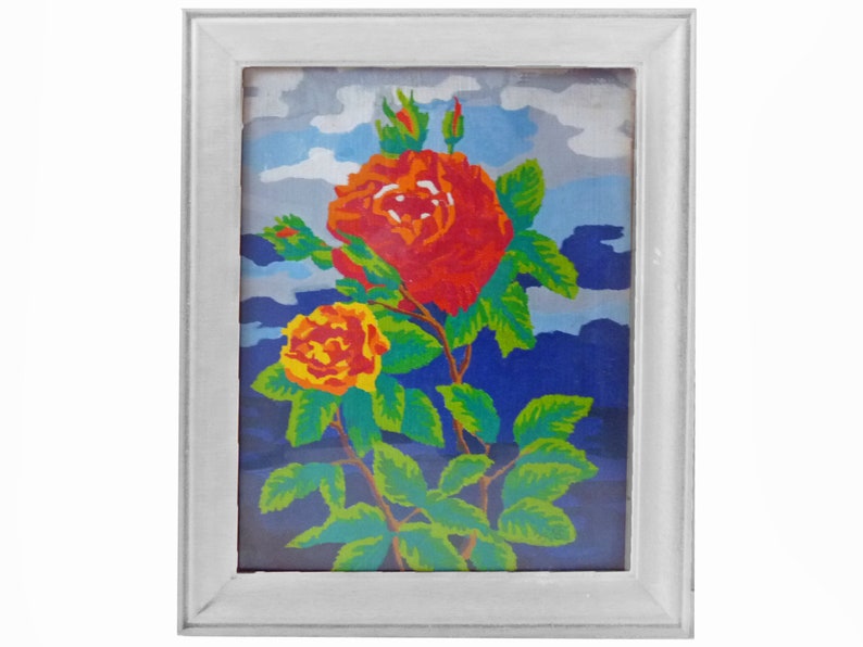 May include: A framed painting of a red and yellow rose with green leaves against a blue and white background.