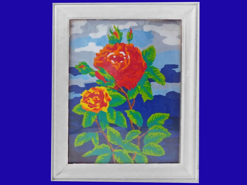 May include: A framed painting of a red and yellow rose with green leaves against a blue and white cloudy sky background.