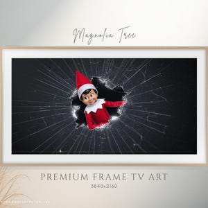 Puede incluir: Una impresión de arte digital enmarcada que presenta un personaje de elfo rompiendo un efecto de vidrio roto. El elfo viste un atuendo y sombrero rojo y blanco. El texto "Magnolia Tree" está en la parte superior y "PREMIUM FRAME TV ART" en la parte inferior.