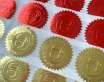 May include: A collection of circular adhesive seals with serrated edges in metallic red and gold. Each seal features an embossed Santa Claus head and the text SANTA'S SPECIAL MAIL NORTH POLE EXPRESS arranged in a circle around the central figure.