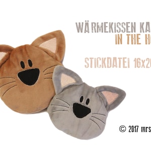 May include: Two plush cat-shaped heating pads, one brown and one gray, with embroidered faces and whiskers. The text "Wärmekissen Katze in the Hoop Stickdatei 16x26cm © 2017 mrsdoodle" is visible in the background.