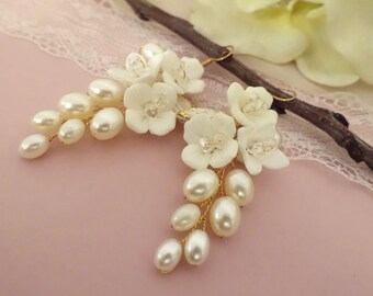 Brautschmuck Ohrhänger in Gold  tropfenförmig mit weißer Keramik Blume und weißen Perlen