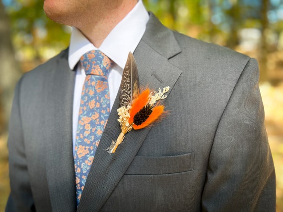 Groom boutonniere with feather and dried wildflowers in boho style