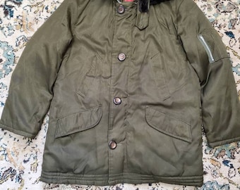 May include: A green military-style jacket with a black faux fur collar and a zipper closure. The jacket has a buttoned flap pocket on the left side and a zippered pocket on the right sleeve.