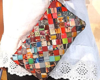 May include: A colorful patchwork clutch bag made from recycled materials. The bag is made up of small squares of different colors and patterns, including red, green, blue, and yellow. The bag has a zipper closure and a small handle.