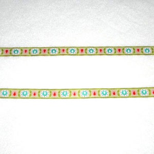Könnte beinhalten: Zwei Reihen grünes Band mit einem sich wiederholenden Muster aus rosa, roten und blauen Blumen und Blättern.
