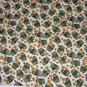 Könnte beinhalten: Ein weißer Stoff mit einem sich wiederholenden Muster aus grünen Fäustlingen, goldenen Sternen und roten Beeren.