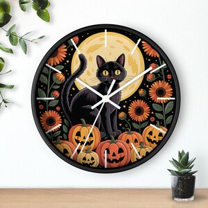 May include: A round black wall clock featuring a black cat with yellow eyes, sitting in front of a full moon. The clock face has orange pumpkins and sunflowers, perfect for Halloween decor.