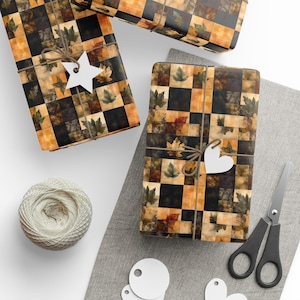 Puede incluir: Cajas de regalo envueltas en papel con temática otoñal con un patrón a cuadros de hojas en tonos marrones, naranjas y verdes. Cada caja está atada con hilo y una etiqueta blanca. También se ven un ovillo de hilo, tijeras y etiquetas en blanco.
