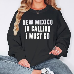 Sweat-shirt New Mexico Is Call I Must Go | Sweat-shirts pour femmes | Déménager dans l'État du Nouveau-Mexique - Cadeau pour homme - Pull à col rond et chemises de vacances - Homme