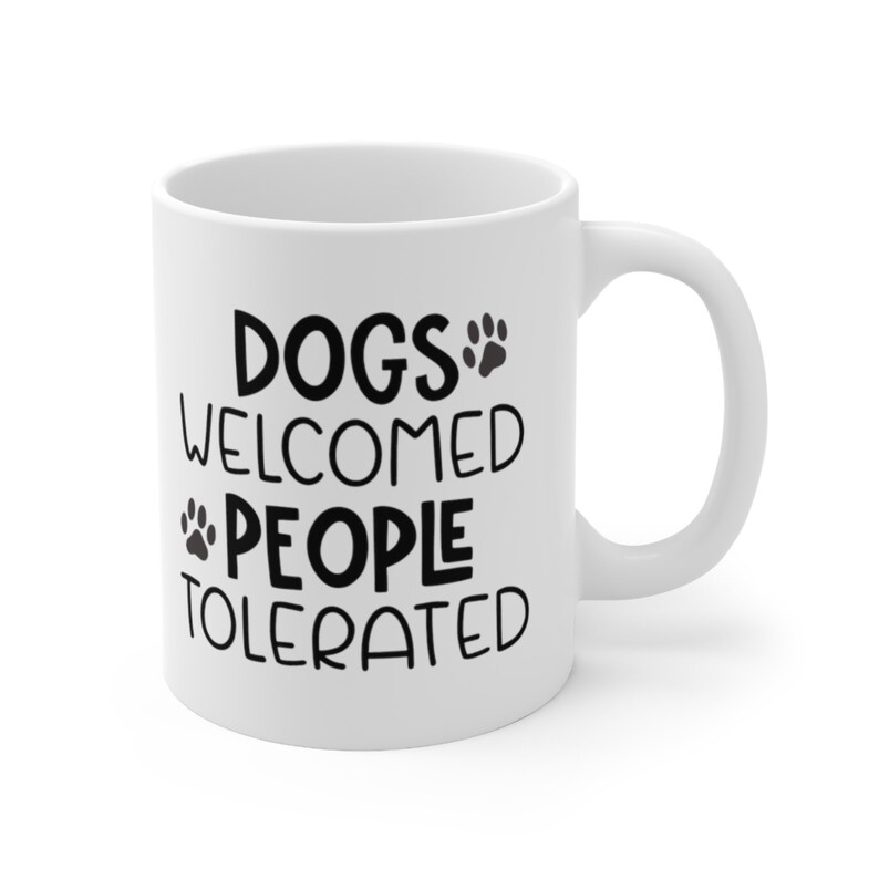 An 11-ounce white, ceramic, coffee cup featuring Sweet Holdings, Dog Welcomed People Tolerated, printed on both the front and back sides of the mug.