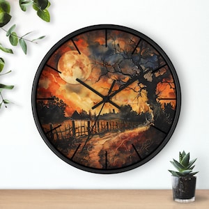 May include: A round wall clock with a black frame. The clock face features a watercolor painting of a full moon, a tree, and a path. The color palette includes orange, yellow, and black.