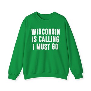 Può includere: Felpa verde con il testo "WISCONSIN IS CALLING I MUST GO" in bianco.