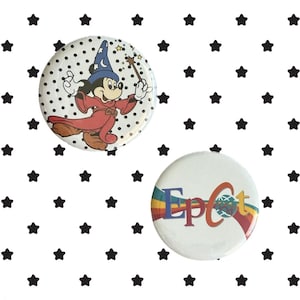 May include: Two circular pin-back buttons. One button features a cartoon mouse wearing a blue wizard hat and red robe, holding a wand. The second button is white with the multicolored text Epcot and a globe graphic over a rainbow arc.