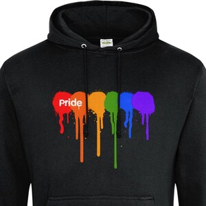 May include: Black hoodie with a Pride-themed design. The design shows the word "Pride" in white, above dripping paint in rainbow colours: red, orange, yellow, green, and purple. The sweatshirt has a front pocket and a drawstring hood.
