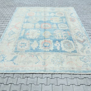 K&ouml;nnte beinhalten: Ein Vintage-Teppich in Blau- und Cremet&ouml;nen. Der Teppich hat ein florales Muster mit einem zentralen Medaillon. Der Teppich ist in gutem Zustand und hat einen abgenutzten Look.