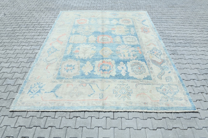 K&ouml;nnte beinhalten: Ein Vintage-Teppich in Blau- und Cremet&ouml;nen. Der Teppich hat ein florales Muster mit einem zentralen Medaillon. Der Teppich ist in gutem Zustand und hat einen abgenutzten Look.