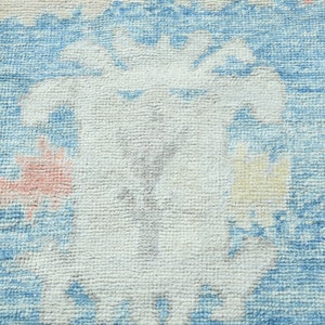 K&ouml;nnte beinhalten: Nahaufnahme eines blauen und wei&szlig;en gemusterten Teppichs mit einem verblassten, Vintage-Look. Der Teppich hat eine weiche, strukturierte Oberfl&auml;che und ist aus gewebten Fasern gefertigt.