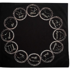 May include: Black square textile featuring a circular arrangement of zodiac constellations. Each constellation is within a gold-colored circle, with the zodiac sign's name in elegant script. The constellations are depicted with small white dots.