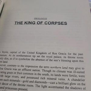 May include: A page from a book titled "The King of Corpses" with text about the capital city of Styrie, the United Kingdom of Roa Gracia, and its northernmost tip where the royal palace is located.