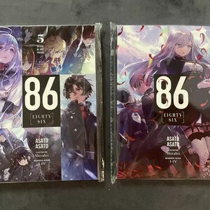 May include: Two volumes of the 86 Eighty-Six manga series. The covers feature anime-style illustrations of characters from the series. The first volume is volume 5, and the second volume is volume 4. The text on the covers reads "86 Eighty-Six" and "Asato Asato".