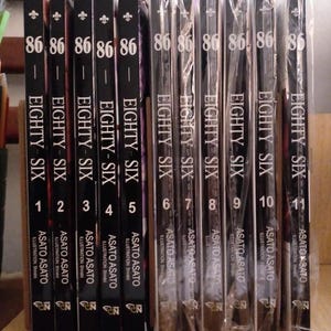 May include: A collection of eleven black and white manga volumes with the title "86 - Eighty Six" and volume numbers 1 through 11. The books are arranged in order from left to right.