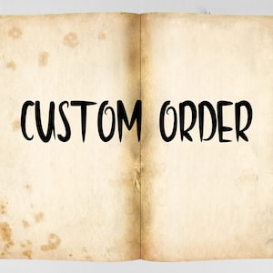 May include: An open book with the words "CUSTOM ORDER" written in black on the pages. The book is old and has a worn, yellowed appearance.