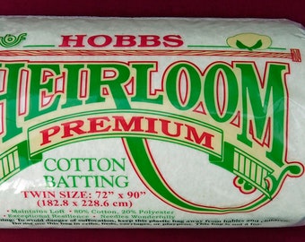 May include: A white package of Hobbs Heirloom Premium Cotton Batting in a twin size, 72 inches by 90 inches (182.8 cm x 228.6 cm). The package is made of 80% cotton and 20% polyester.