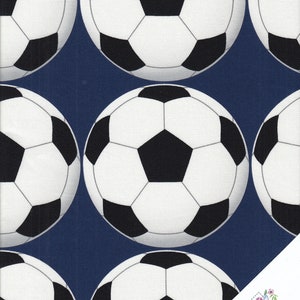 Può includere: Un tessuto blu navy con un motivo ripetuto di palloni da calcio bianchi e neri.