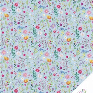 Könnte beinhalten: Ein hellblauer Stoff mit einem sich wiederholenden Blumenmuster. Das Design zeigt eine Vielzahl farbenfroher Blumen, darunter rosa, gelbe, lila und weiße, zusammen mit grünen Blättern. Die Blumen sind über den Stoff verstreut und erzeugen ein lebendiges und fröhliches Aussehen.