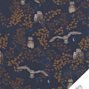 Op de afbeelding: Een donkerblauwe stof met een herhalend patroon van bruine uilen die op takken zitten of vliegen, afgewisseld met bruine bladeren en kleine witte maansikkels. Een wit hoeklabel toont de tekst Quilt Shop Ruth Baudisch.