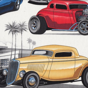 May include: Three vintage hot rods, one blue, one red and one yellow, are parked in front of a diner with an "LA Diner" sign. Palm trees are in the background.