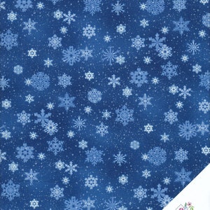 Peut inclure: Un tissu bleu foncé présentant un motif répétitif de flocons de neige blancs et bleu clair de tailles et de designs variés. Une étiquette blanche dans le coin affiche le texte Quilt Shop Ruth Baudisch avec une petite illustration florale.