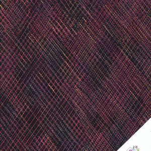 May include: Black fabric with a diagonal pattern of thin, colourful lines in shades of pink, orange, and yellow.