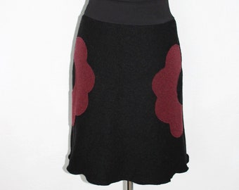 Black knee-length wool skirt with dark red flower-shaped pockets