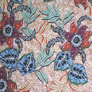Viscose jersey pattern with flowers & leaves, slightly African orange/dark red/blue on beige