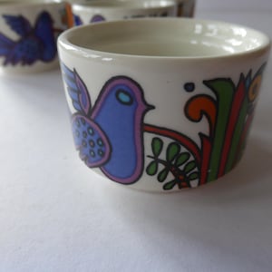 Könnte beinhalten: Ein Set aus drei Keramikbechern mit gesprenkelter, matter Oberfläche. Die Becher sind in Creme-, Hellgrau- und Dunkelgrautönen gehalten. Jeder Becher hat ein schlichtes, minimalistisches Design.