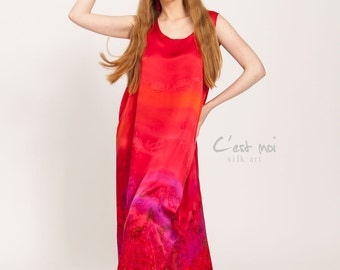 May include: A sleeveless red silk dress with a gradient of orange, pink, and purple hues. The dress has a scoop neck and a flowing silhouette. The dress is made by C'est moi silk art.