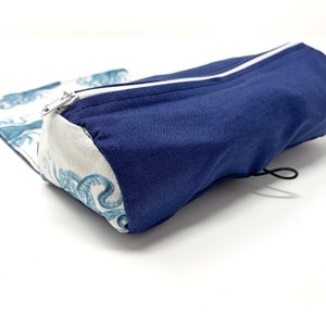 Pode incluir: Um estojo de l&aacute;pis de tecido azul e branco com fecho de correr e cord&atilde;o. O estojo apresenta um padr&atilde;o de polvos azuis e brancos.