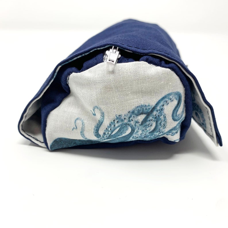 Pode incluir: Uma bolsa azul marinho com z&iacute;per com um forro de tecido branco com um estampado de polvo azul e branco.