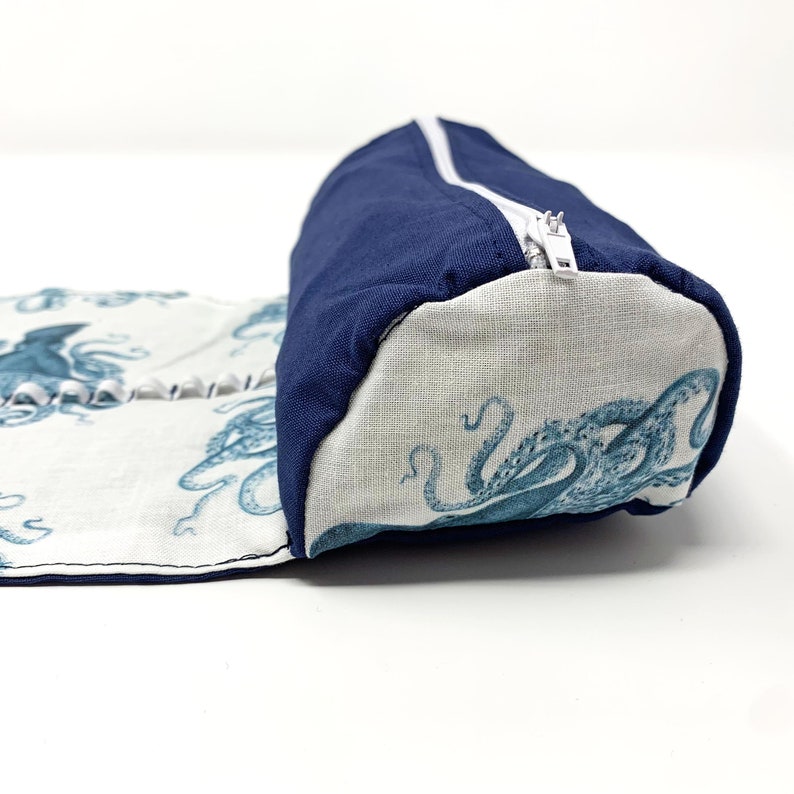 Pode incluir: Um estojo para l&aacute;pis de tecido azul e branco com fecho de correr. O estojo apresenta um padr&atilde;o de polvos azuis sobre um fundo branco.