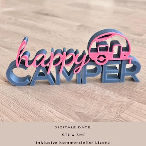 Op de afbeelding: Een 3D-geprint bord met de tekst "happy CAMPER" in grijs en roze. Het woord "happy" is cursief geschreven en een roze camper staat bovenop de letter "R". Het bord staat op een houten oppervlak. De tekst "DIGITALE DATEI" staat onderaan.