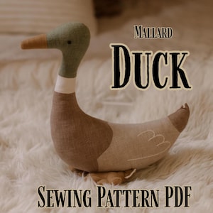 May include: A stuffed mallard duck made from fabric, featuring a green head, brown body, and tan wings. The duck has a white neck ring and a brown beak. Text on the image reads "Mallard Duck Sewing Pattern PDF".