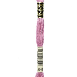 May include: A pink embroidery floss spool with the DMC brand name and number 3608 printed on the label.