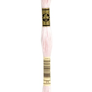 May include: A skein of DMC embroidery floss in colour 23, a light pink. The floss is wrapped around a cardboard spool with a gold label that reads "DMC Special Mouliné 25 8.7m (8.7 yd)".
