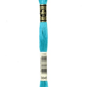 May include: A spool of DMC embroidery floss in colour 3845, a bright turquoise blue. The spool has a gold label with the DMC logo and the text "Mouline Special 25 8m (8.7 yd)".