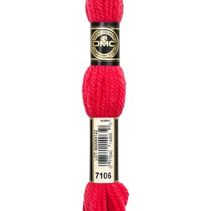 May include: A skein of DMC tapestry wool in colour 7106, a bright red. The skein is wrapped in a black and gold label with the DMC logo and the words "Laine Colbert Tapestry Wool".