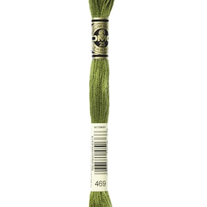 May include: A spool of DMC embroidery floss in colour 469, a medium green shade. The spool is labelled with the DMC logo and the colour number. The text on the label reads "Mouline Special DMC 25 8 m (8.7 yds) 6612045H Para venta solo fuera de la U.6. 469"