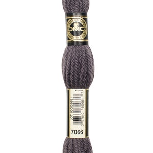 May include: A skein of DMC tapestry wool in a dark grey colour. The skein is wrapped in a black and gold label with the DMC logo and the text "Laine Colberty Tapestry Wool". The label also includes a barcode and the number "7066".